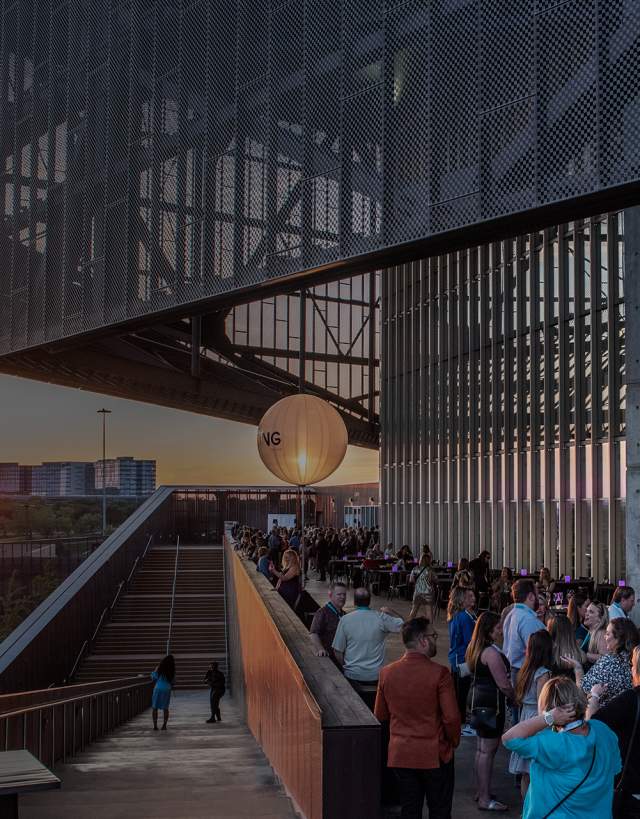 Attendees standing outside the Irving Convention Center at dusk.