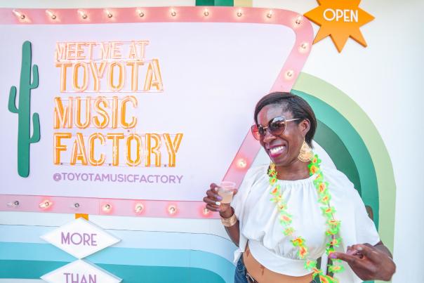 Woman in front of Meet Me at Toyota Music Factory sign
