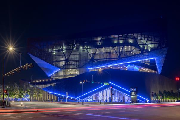 Exterior picture of the Irving Convention Center at night illimunated with blue light