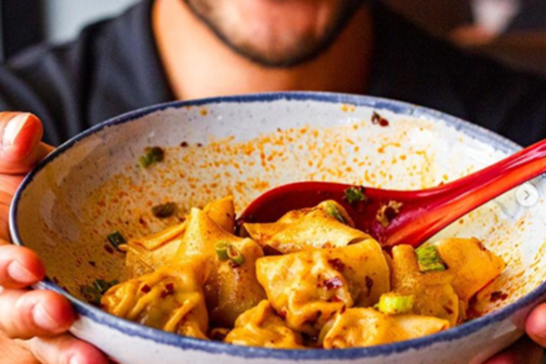 Man holding bowl of dumplings
