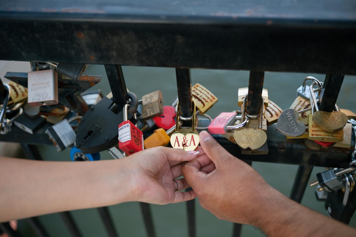 Couple holding the love lock with initals A&A.
