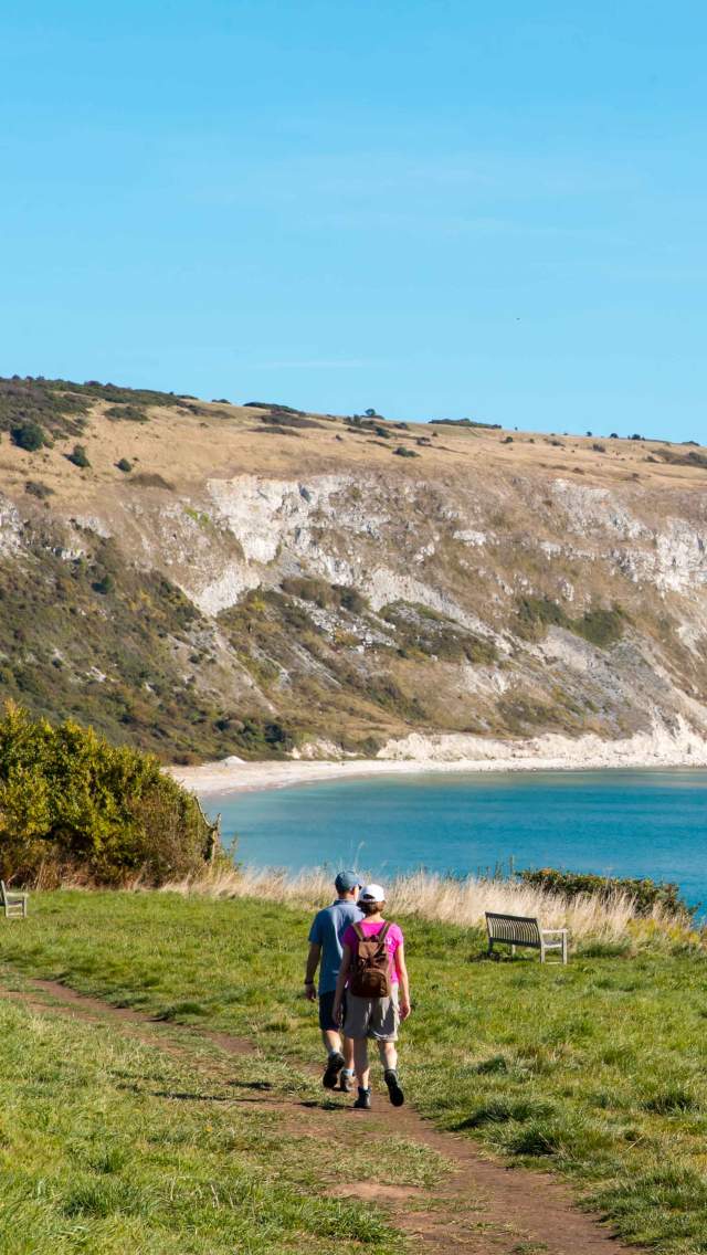 Man and woman walking towards Ballard Down in Swanage, Dorset
