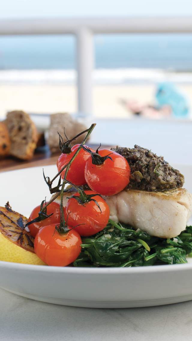 Meal of fish and vegetables in a restaurant next to the beach