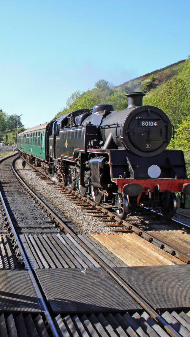 Swanage Railway guard standing on the platform at Corfe Castle Station, Dorset