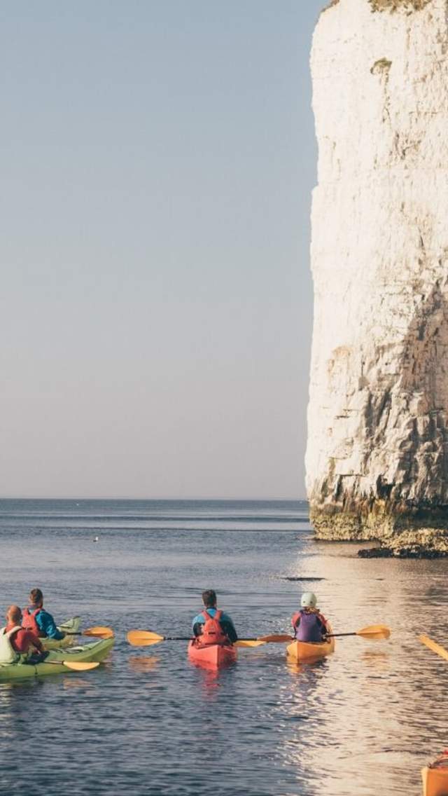 A group of kayaks at the base of Old Harry Rocks