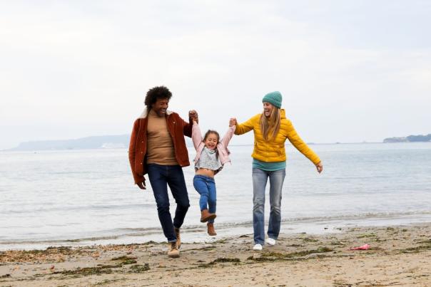 A family enjoying time on the beach during autumn at Bowleaze Cove Holiday Park & Spa in Weymouth