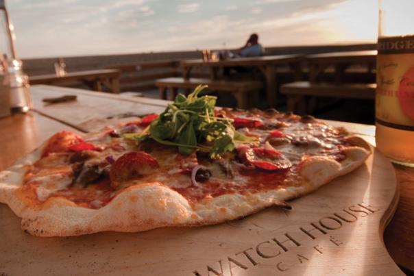 Pizza on a wooden board at Watch House Cafe, Dorset