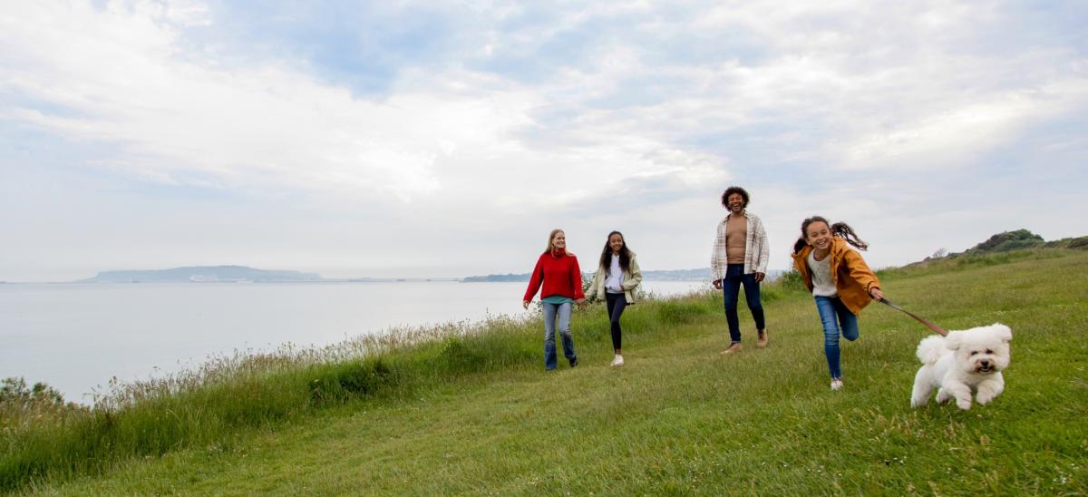 A family walking their dog during autumn near Bowleaze Cove in Dorset