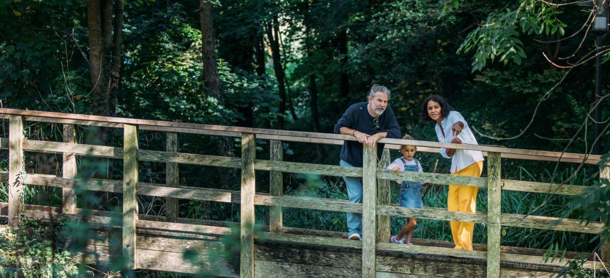 A family of three people standing on a bridge at Osmington Mills Lodge Park in Dorset