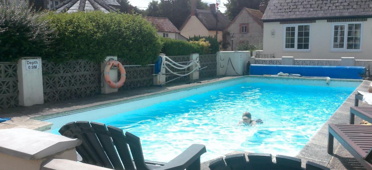 A woman swimming in the outdoor pool at The Poachers Inn pub in Dorset