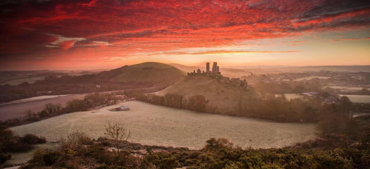 A dramatic red sky sunrise over Corfe Castle in Dorset, copyright Matt Pinner