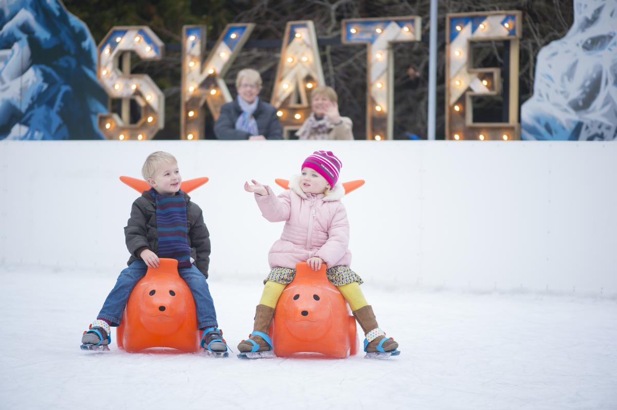 Two children ice-skating in Bournemouth's Lower Gardens, Dorset